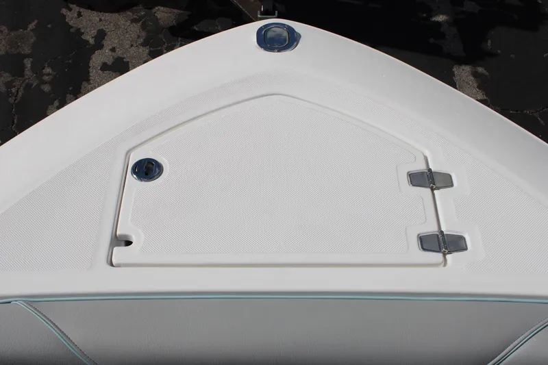Slide: The Image of 2024 Regal LS9 Surf boat bow storage compartment with white hatch and stainless steel hinges. - 41