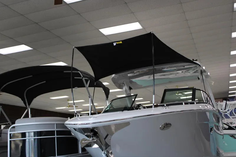 Slide: The Image of 2024 Regal LS9 Surf boat on display in showroom with black canopy. - 48