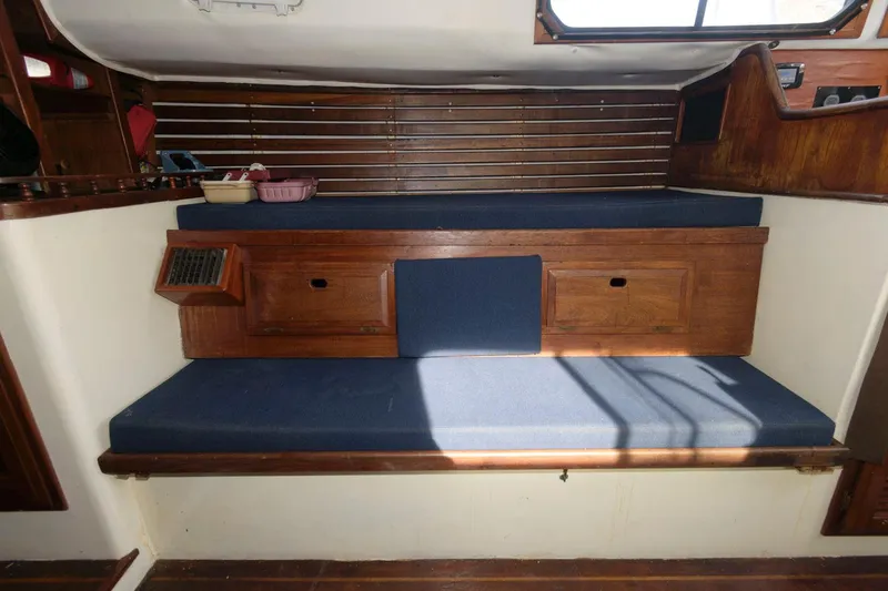 Slide: The Image of 1976 Downeast 38 interior with wooden cabinetry and blue cushions. - 13