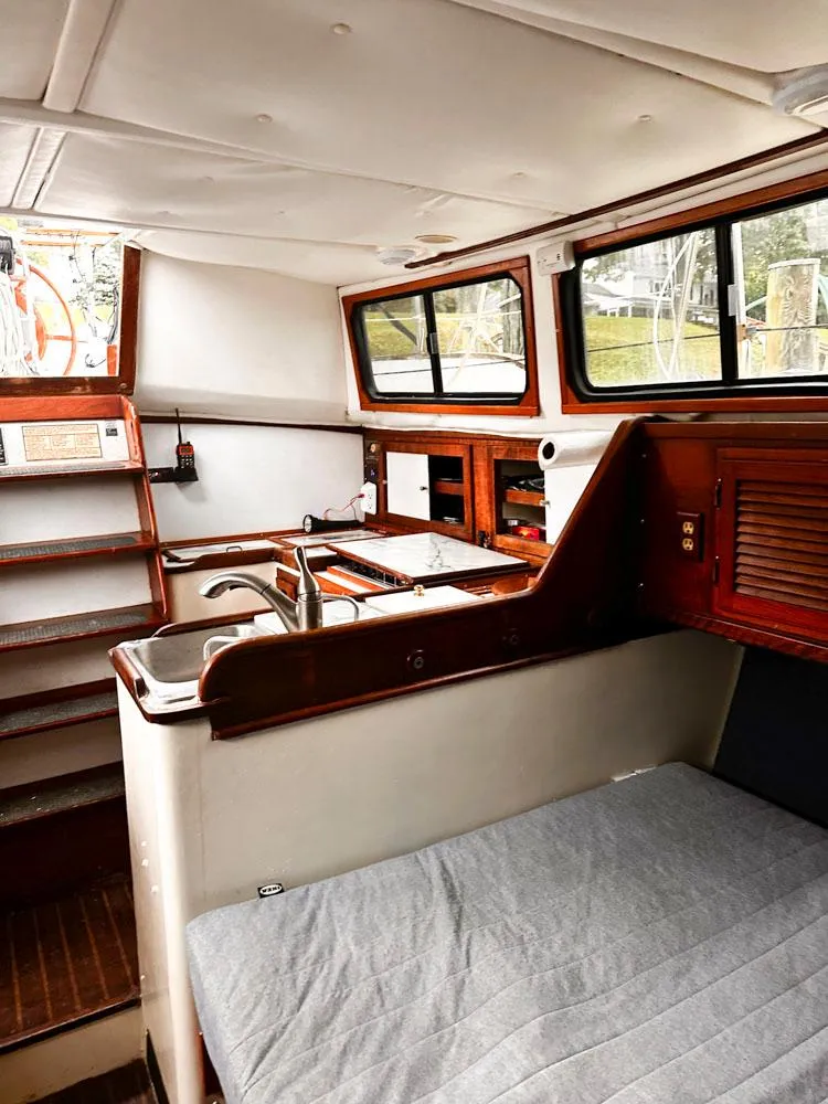 Slide: The Image of Interior of 1976 Downeast 38 sailboat with wooden cabinetry and compact kitchen area. - 17
