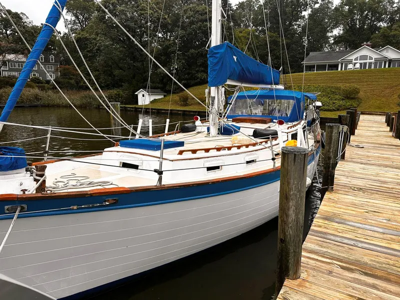 Slide: The Image of 1976 Downeast 38 sailboat docked at a wooden pier. - 2