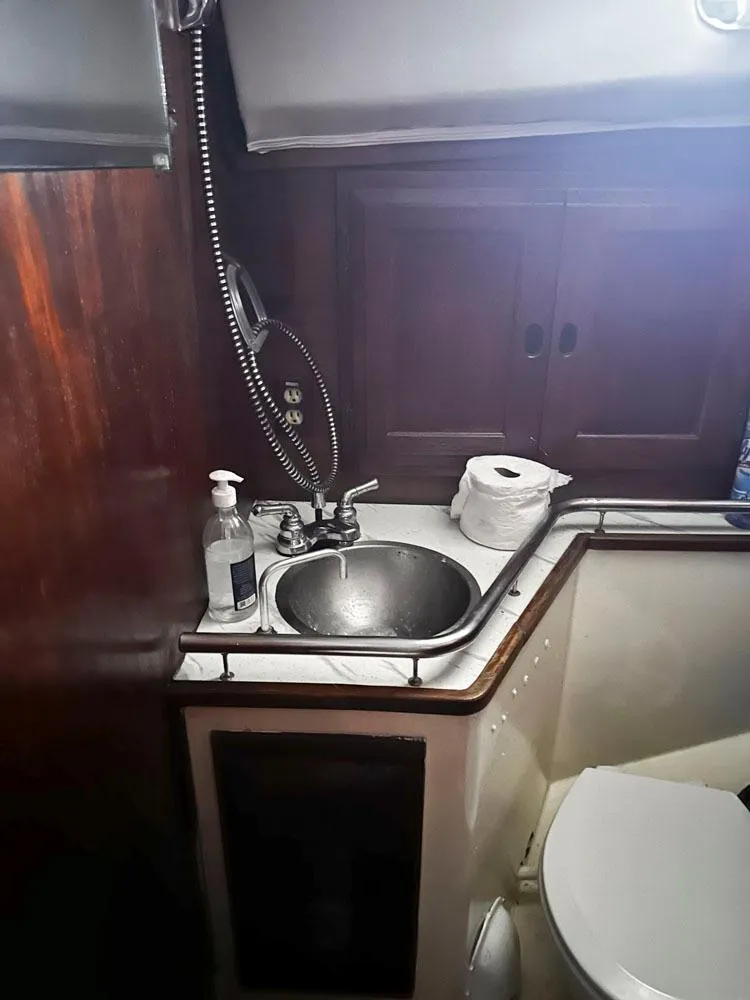 Slide: The Image of 1976 Downeast 38 boat bathroom with sink, toilet, and storage cabinets. - 21