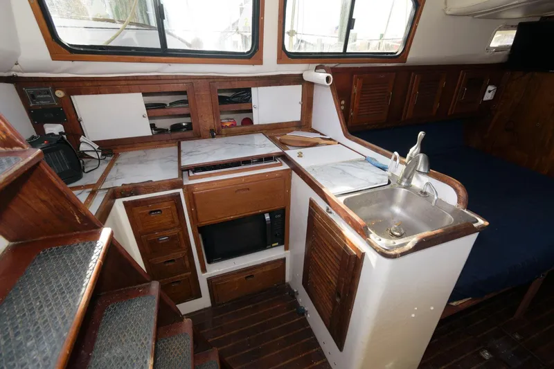 Slide: The Image of 1976 Downeast 38 boat interior with kitchen sink, microwave, and wooden cabinetry. - 9