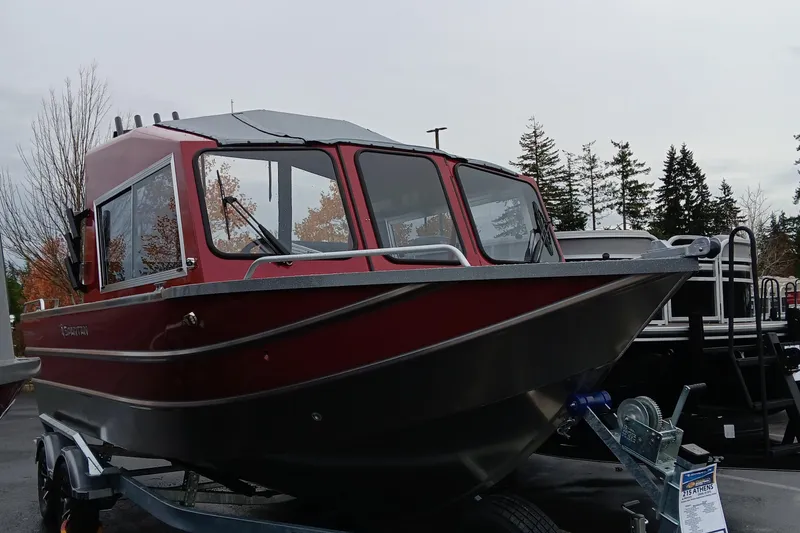 Slide: The Image of 2024 Spartan 215 Athens boat on a trailer in a parking lot. - 2