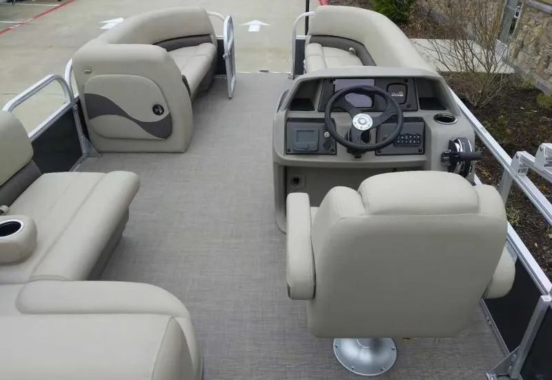 Slide: The Image of 2024 Sun Tracker Party Barge 18 DLX interior with beige seating and modern helm. - 4