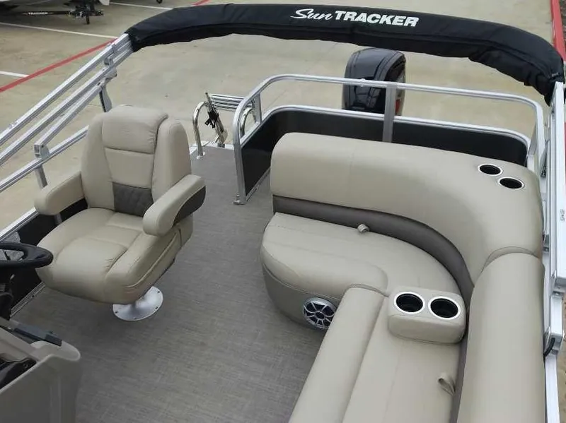 Slide: The Image of 2024 Sun Tracker Party Barge 18 DLX interior with beige seating and cup holders. - 5