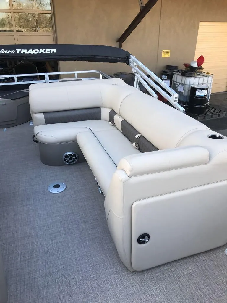 Slide: The Image of 2024 Sun Tracker SportFish 20 DLX boat with beige seating and spacious deck. - 11