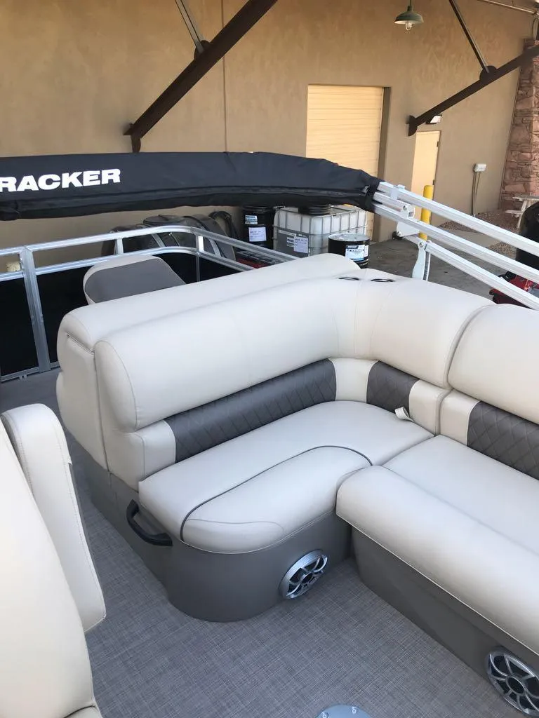 Slide: The Image of 2024 Sun Tracker SportFish 20 DLX pontoon boat with beige seating and black canopy. - 13