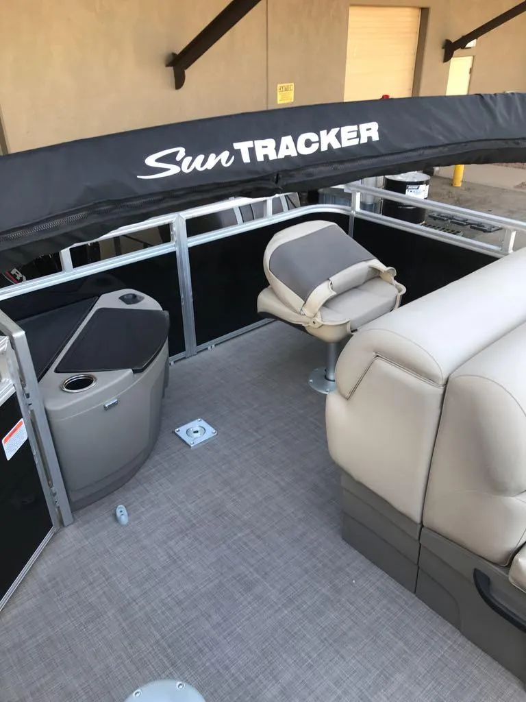 Slide: The Image of 2024 Sun Tracker SportFish 20 DLX pontoon boat interior with seating and storage. - 7