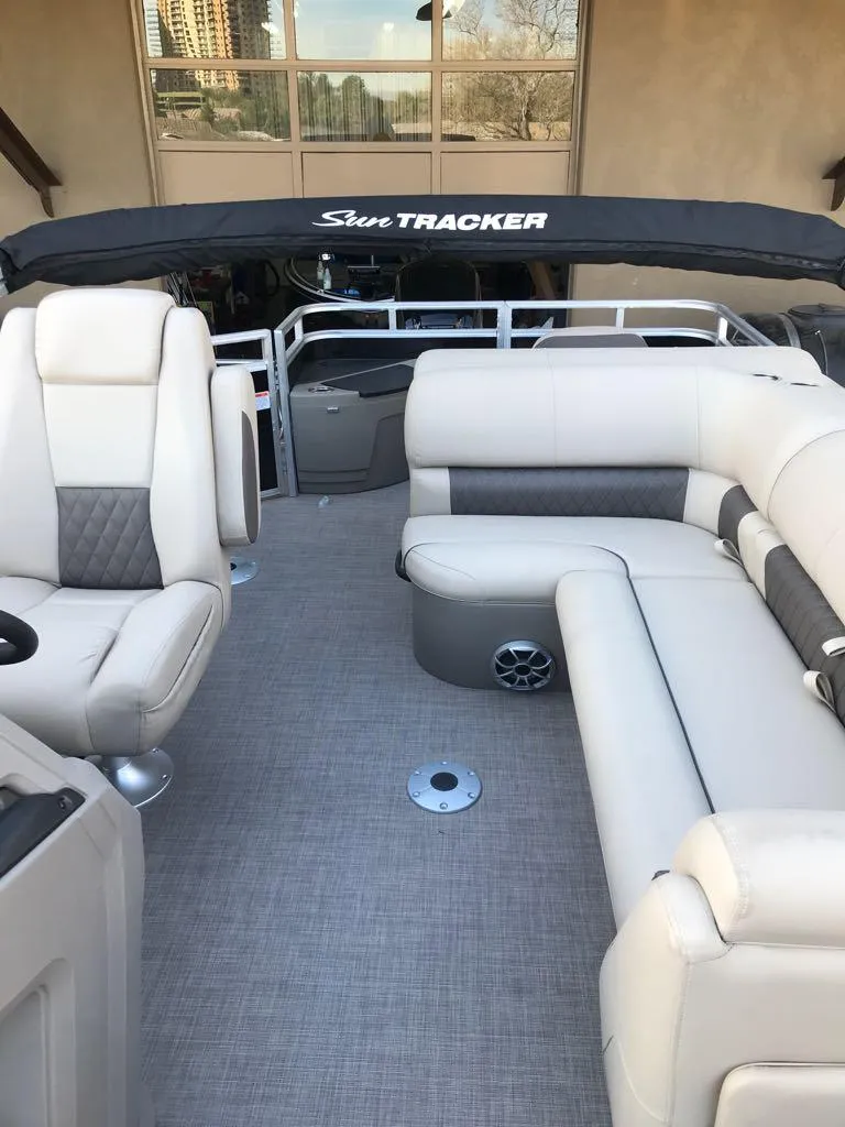 Slide: The Image of 2024 Sun Tracker SportFish 20 DLX pontoon boat interior with plush seating and canopy. - 9