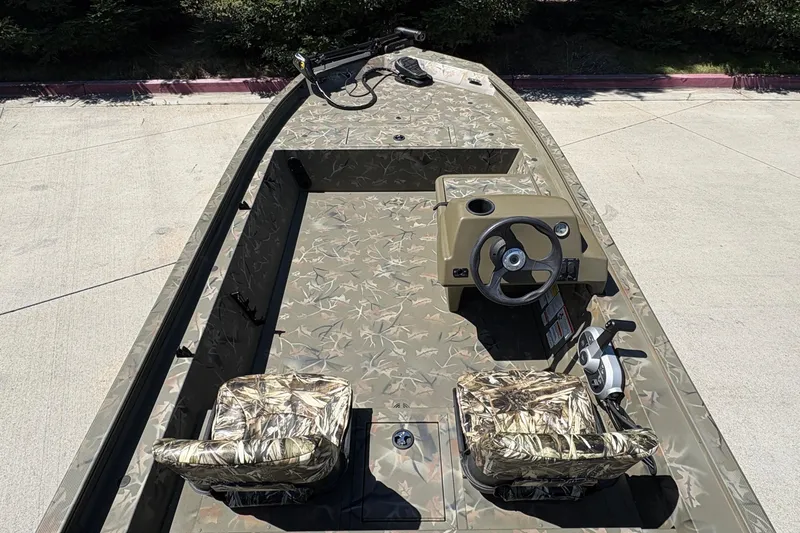 Slide: The Image of 2024 Tracker Grizzly 1754 SC boat with camouflage seats and steering console. - 15