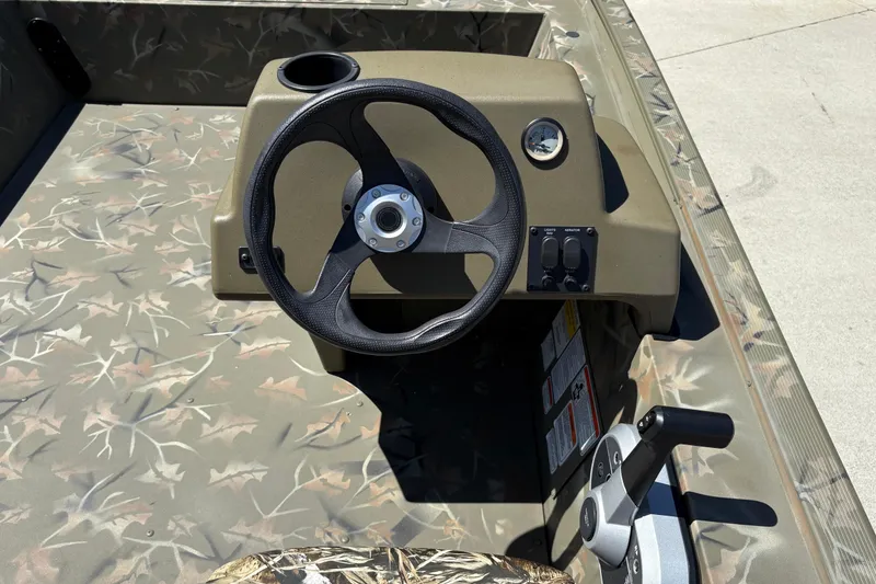 Slide: The Image of 2024 Tracker Grizzly 1754 SC boat steering console with camouflage design. - 20