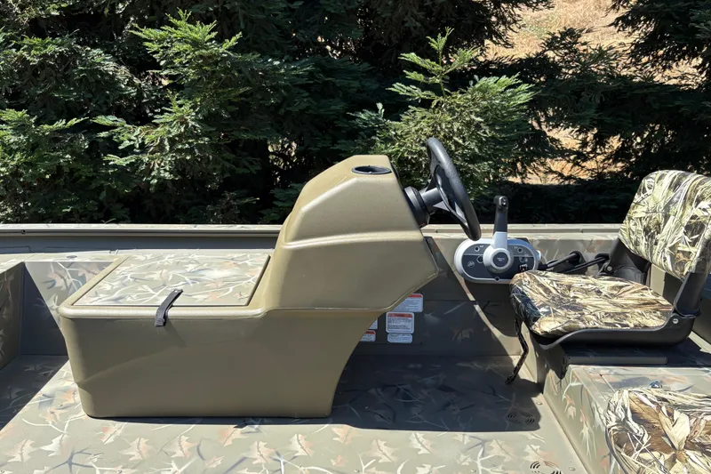 Slide: The Image of 2024 Tracker Grizzly 1754 SC boat interior with camouflage seating and steering console. - 17