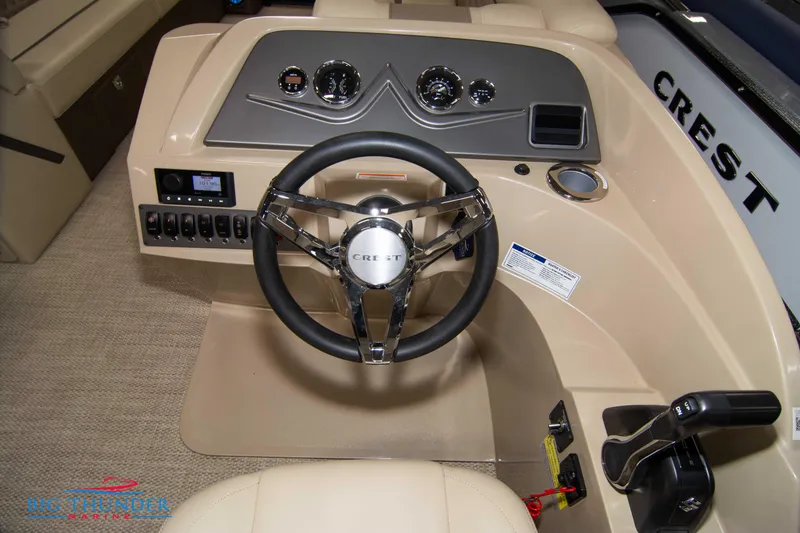Slide: The Image of 2023 Crest Classic DLX 240 SLC boat dashboard with steering wheel and control panel. - 25