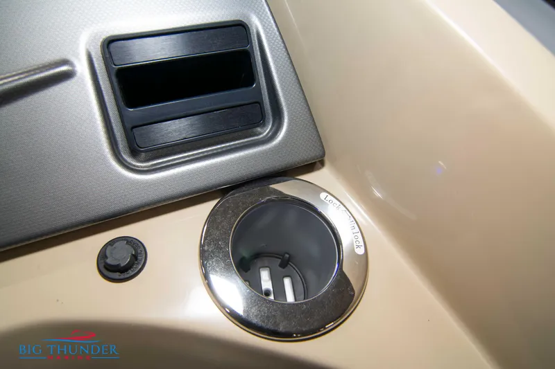 Slide: The Image of 2023 Crest Classic DLX 240 SLC boat dashboard with cup holder and control panel. - 28