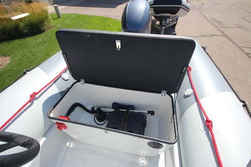 Slide: The Image of 2024 Zodiac Open 4.8 NEO 70hp boat storage compartment with open lid. - 11