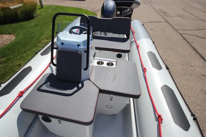 Slide: The Image of 2024 Zodiac Open 4.8 NEO 70hp inflatable boat interior with seating and console. - 2