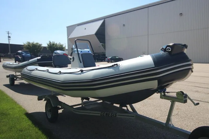 Slide: The Image of 2024 Zodiac Open 4.8 NEO 70hp inflatable boat on trailer outside warehouse. - 8