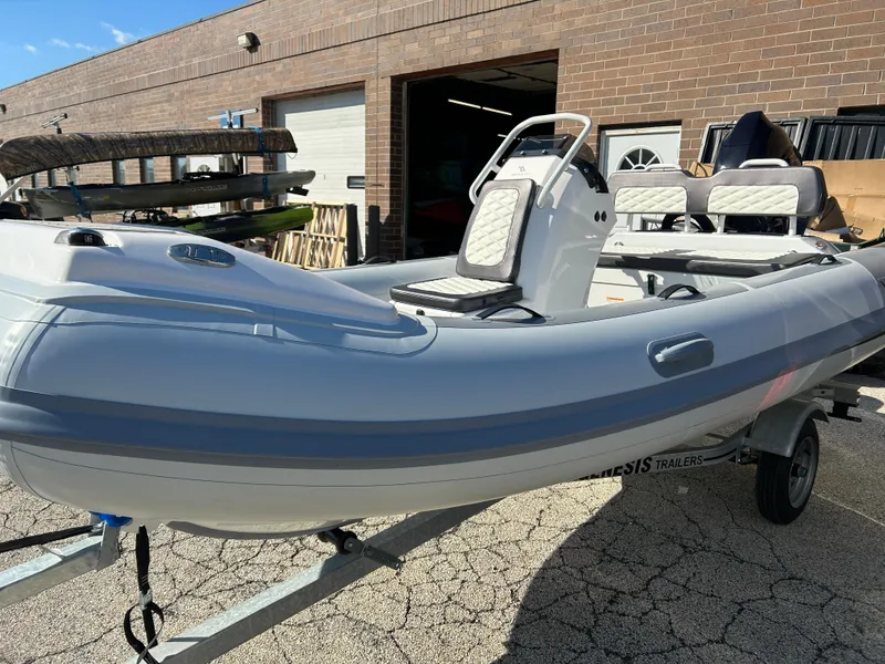 Slide: The Image of 2023 Highfield Sport 420 inflatable boat on a trailer outside a brick building. - 5