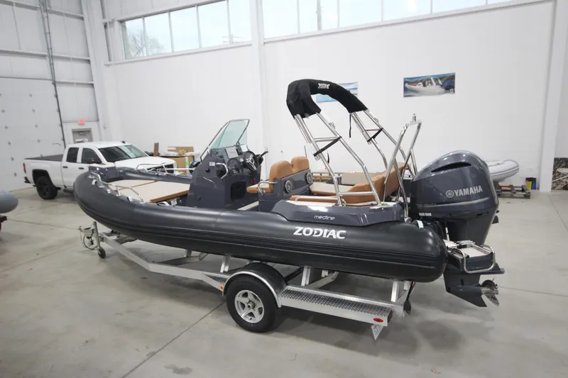 Slide: The Image of 2024 Zodiac Medline 6.8 NEO 250hp boat in stock, displayed in a showroom. - 0