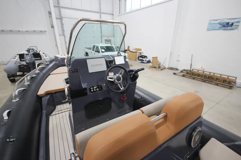 Slide: The Image of 2024 Zodiac Medline 6.8 NEO 250hp boat interior with steering console and tan seating. - 10
