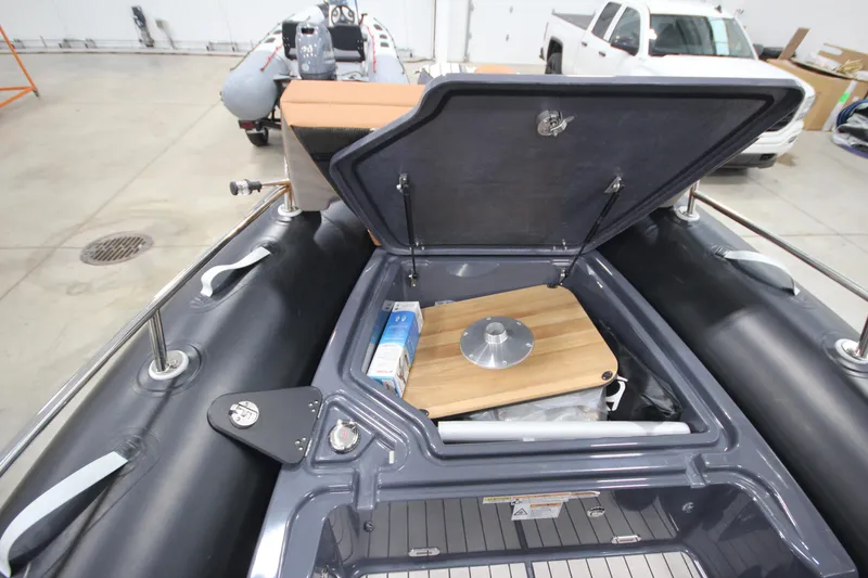 Slide: The Image of 2024 Zodiac Medline 6.8 NEO 250hp boat storage compartment open in a showroom. - 16