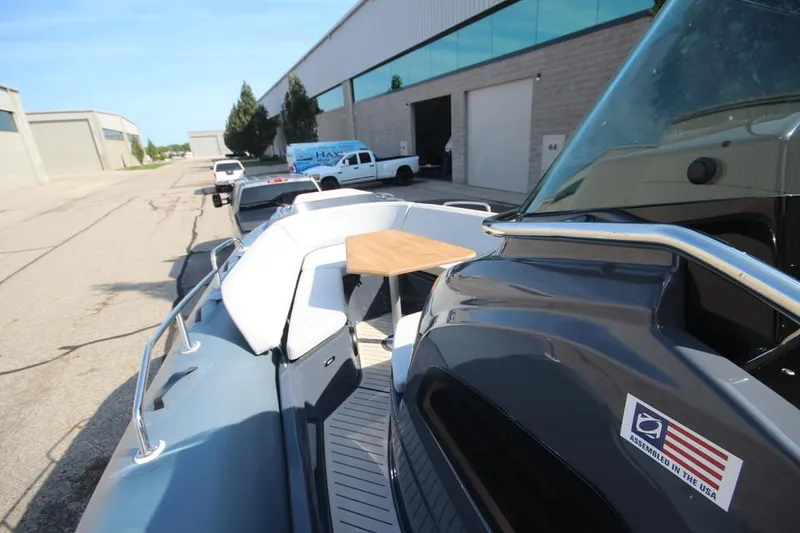 Slide: The Image of 2024 Zodiac MEDLINE 9 NEO boat with seating and table, parked near industrial buildings. - 26