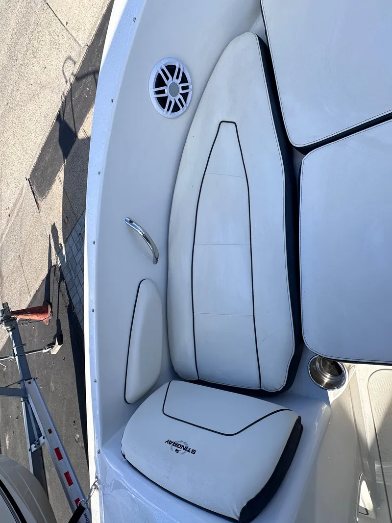Slide: The Image of 2024 Stingray 172 SC boat interior with white cushioned seating and speaker. - 17