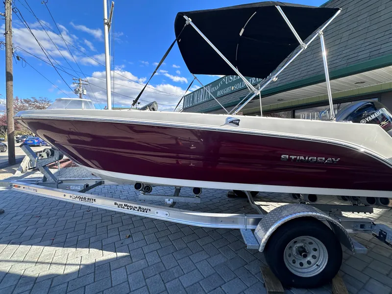 Slide: The Image of 2024 Stingray 172 SC boat on a trailer with a black canopy. - 23