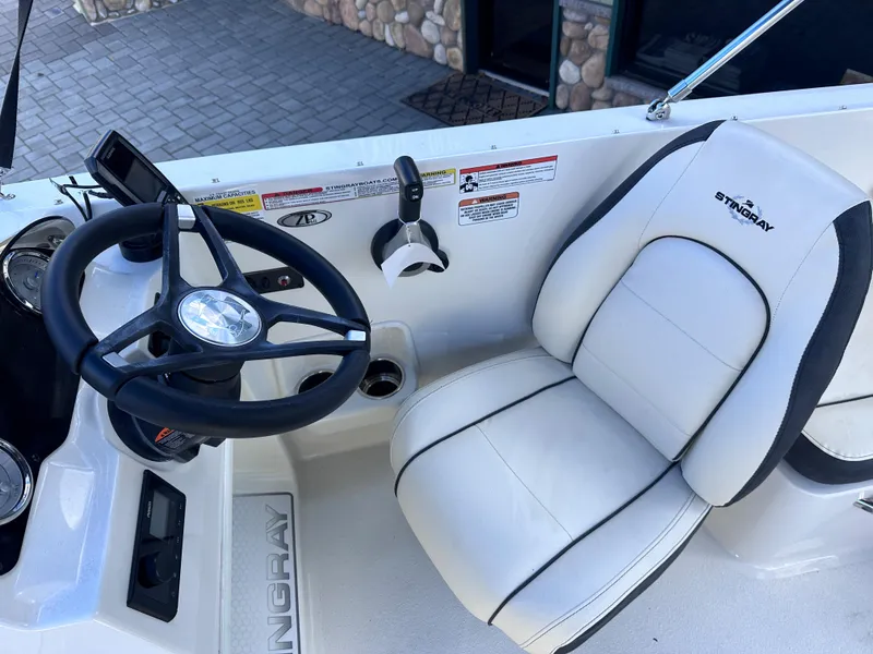 Slide: The Image of 2024 Stingray 172 SC boat cockpit with steering wheel and captain's chair. - 8