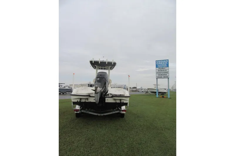 Slide: The Image of 2019 Boston Whaler 240 Dauntless boat on trailer, parked on grass. - 2