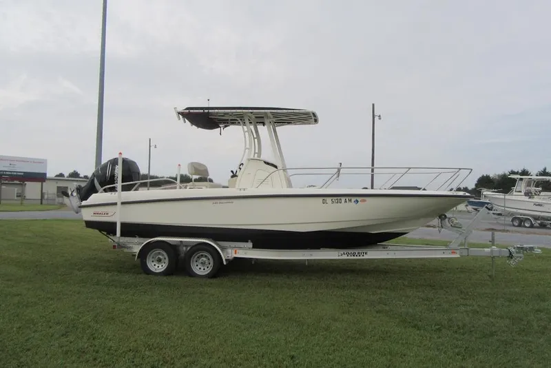 Slide: The Image of 2019 Boston Whaler 240 Dauntless boat on trailer, parked on grassy roadside. - 3