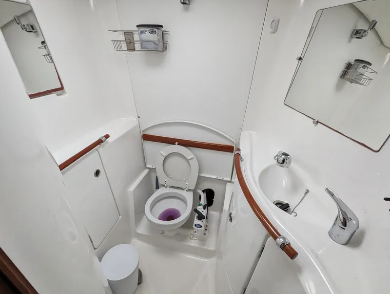 Slide: The Image of 2005 Beneteau 393 yacht bathroom with toilet, sink, and mirror in compact layout. - 10