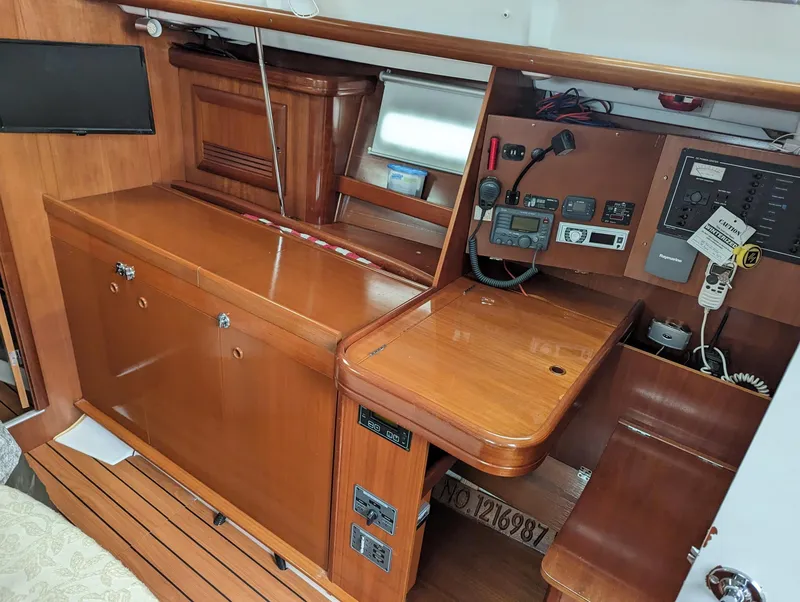 Slide: The Image of 2005 Beneteau 393 yacht interior with navigation station and wooden cabinetry. - 15