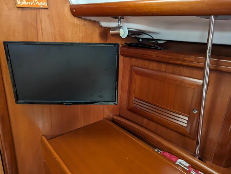 Slide: The Image of Interior of 2005 Beneteau 393 yacht with mounted TV and wooden cabinetry. - 17