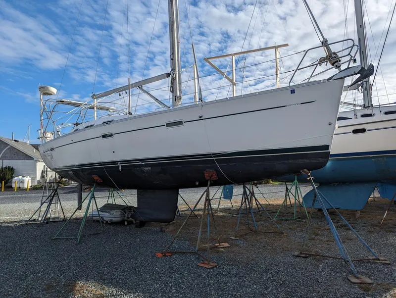 Slide: The Image of 2005 Beneteau 393 sailboat on stands, displayed outdoors under a blue sky. - 2