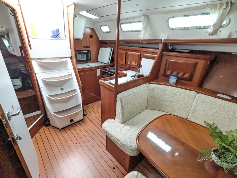 Slide: The Image of Interior of a 2005 Beneteau 393 sailboat with wood finish and cozy seating area. - 20