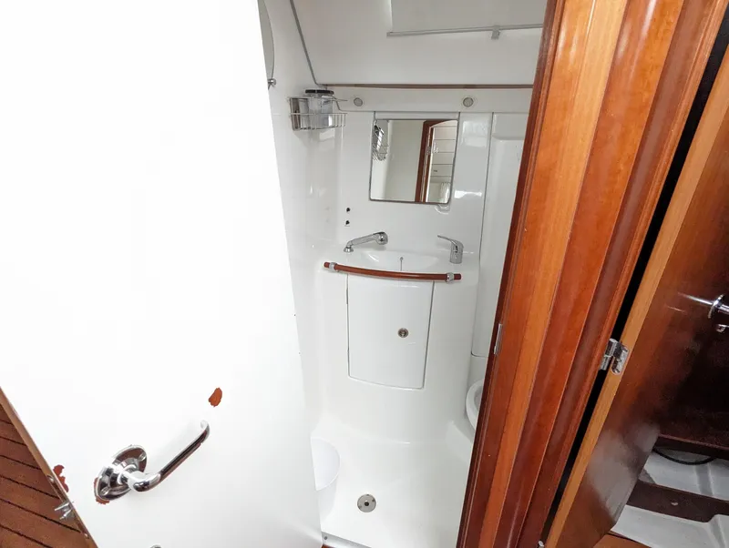Slide: The Image of 2005 Beneteau 393 yacht bathroom with compact design and wooden accents. - 22