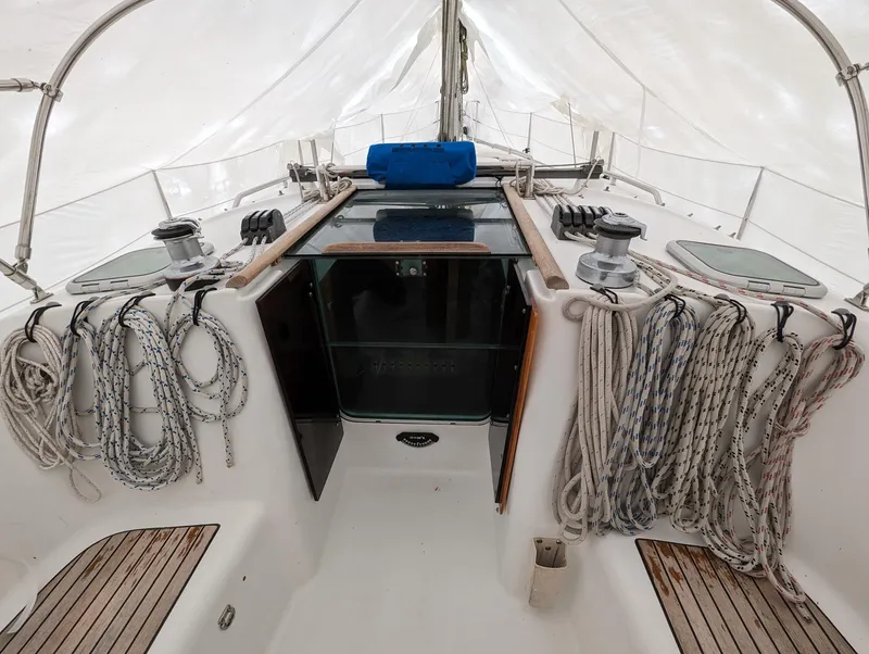 Slide: The Image of 2005 Beneteau 393 sailboat cockpit with ropes and winches under a protective cover. - 24