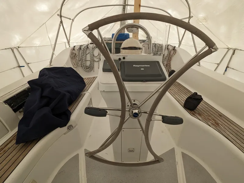 Slide: The Image of 2005 Beneteau 393 sailboat cockpit with steering wheel and navigation equipment. - 31