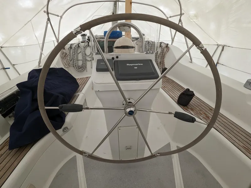 Slide: The Image of Steering wheel of a 2005 Beneteau 393 sailboat, featuring a Raymarine navigation system. - 32