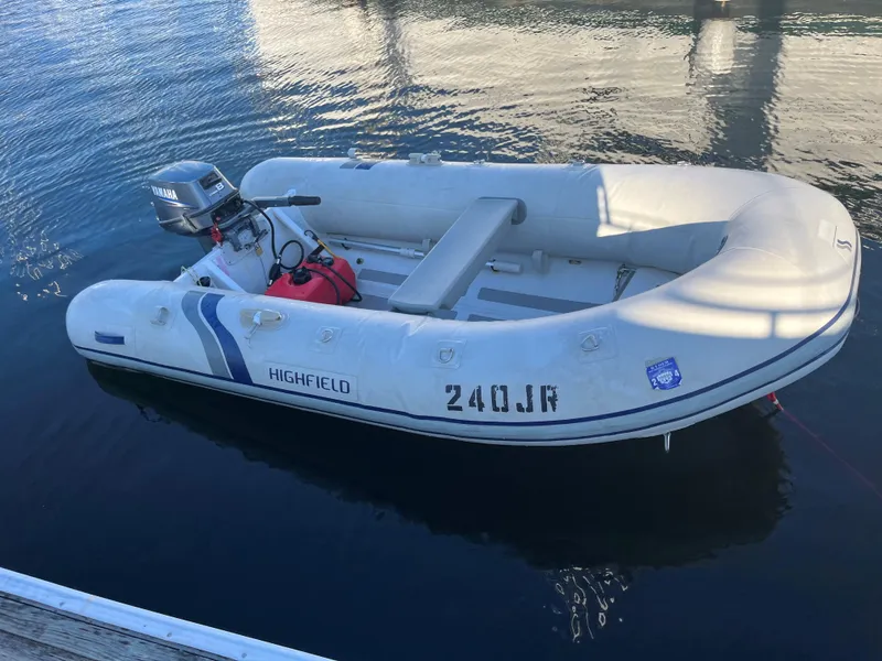 Slide: The Image of Inflatable Highfield boat with Yamaha motor docked on calm water. - 33