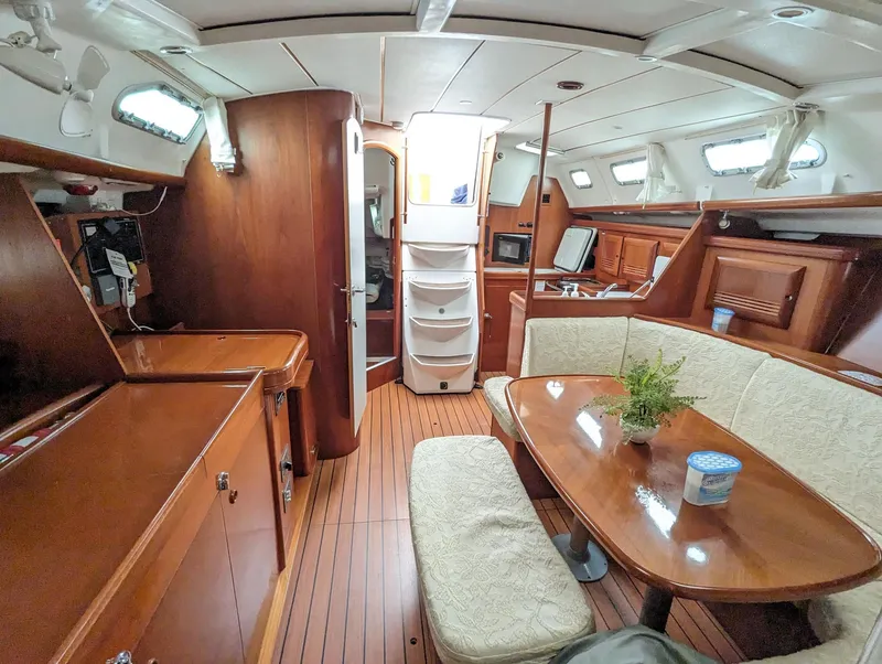 Slide: The Image of Interior of a 2005 Beneteau 393 sailboat with wood finish and cozy seating area. - 9