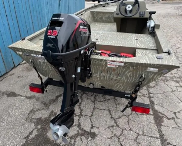 Slide: The Image of 2024 Tracker Grizzly 1648 SC boat with Mercury 9.9 motor, parked on a trailer. - 3