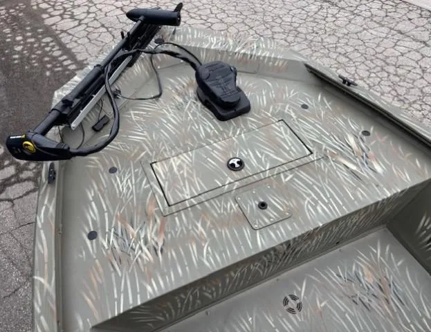 Slide: The Image of 2024 Tracker Grizzly 1648 SC boat with camo pattern and trolling motor. - 5