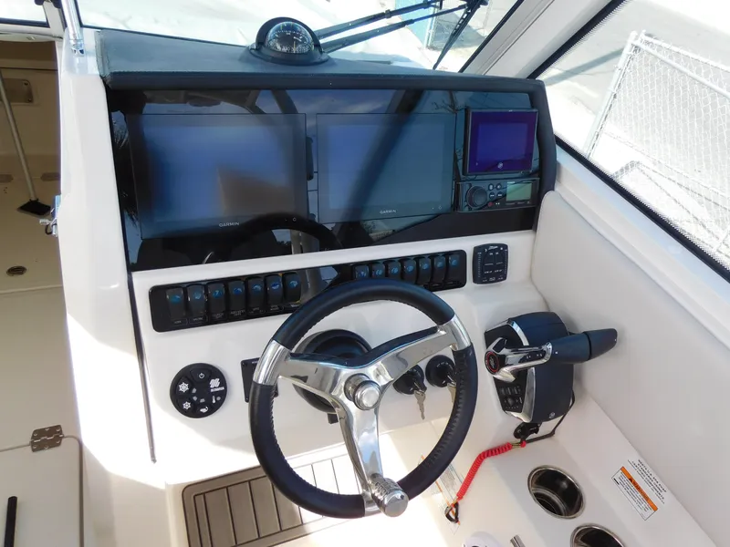 Slide: The Image of 2024 Sailfish 276 DC boat dashboard with steering wheel and navigation controls. - 5