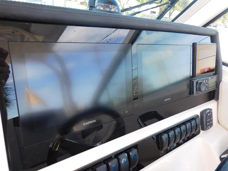 Slide: The Image of 2024 Sailfish 276 DC dashboard with dual Garmin displays and control panel. - 6