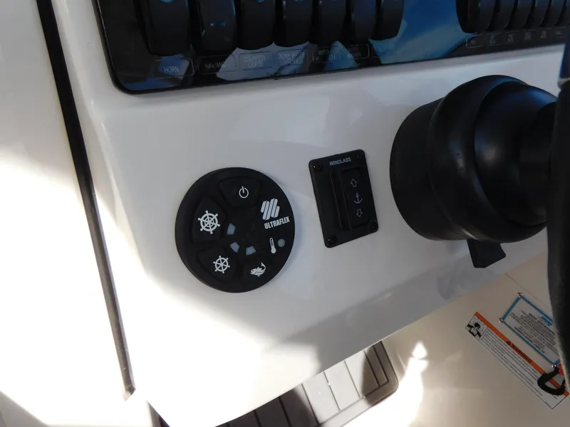 Slide: The Image of Control panel of 2024 Sailfish 276 DC boat with steering wheel and buttons. - 9