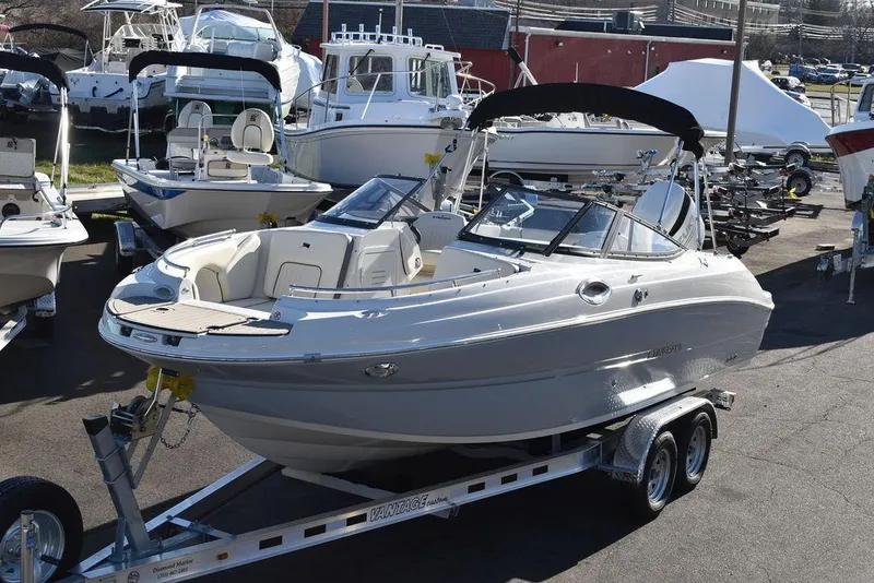 Slide: The Image of 2024 Stingray 231DC boat on a trailer in a marina. - 2