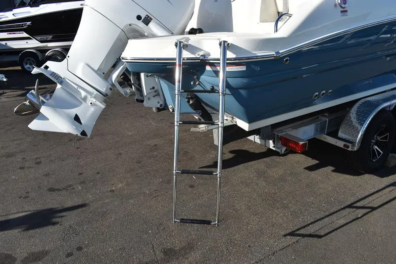 Slide: The Image of 2024 Stingray 231DC boat with ladder and outboard motor on trailer. - 21